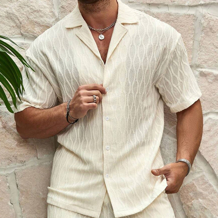Mann trägt beiges Herren Sommerset: Kurzarmhemd & Shorts. Modernes Casual Outfit für warme Tage & Urlaub.