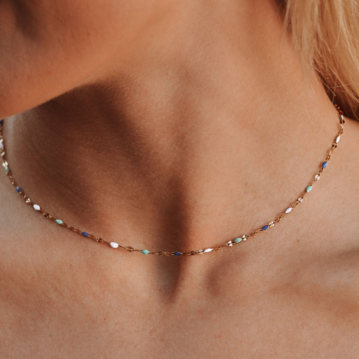 Nahaufnahme einer Damen Choker Halskette mit blauen und weißen Emaille-Akzenten am Hals