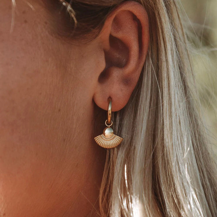 Damen Creolen in Gold mit Boho-Anhänger am Ohr getragen