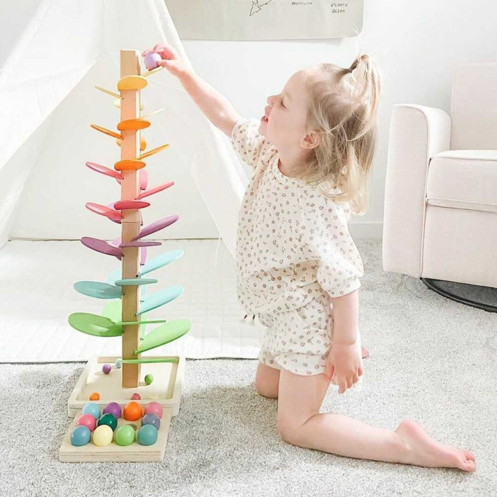 Kind spielt mit buntem Holz-Murmelbaum, Montessori-Spielzeug, Kinderzimmer, pädagogisch.