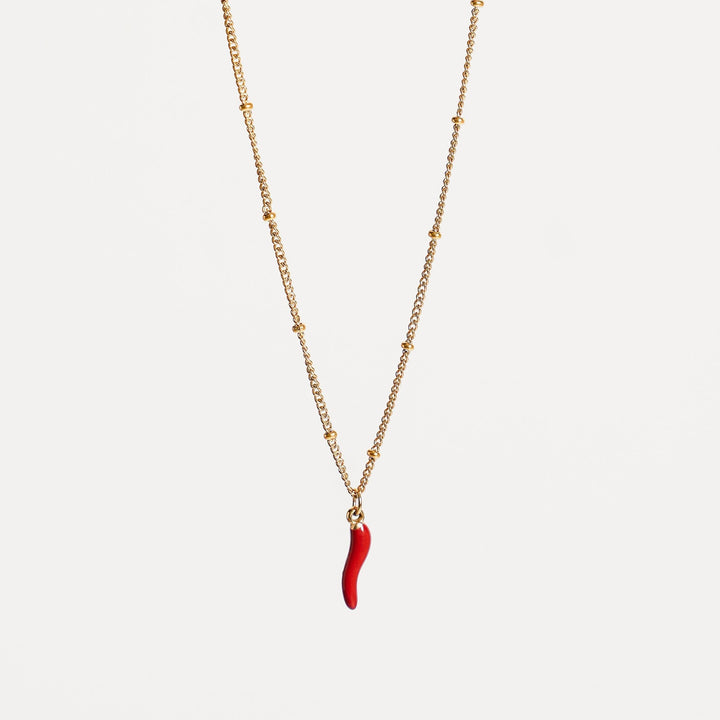 Damen Halskette mit glänzendem Goldton und rotem Chili-Anhänger.