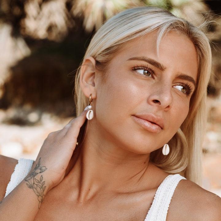 Hochwertige goldene Damen Creolen mit zarter Muschel & Perle, wasserdicht & hypoallergen, elegant.