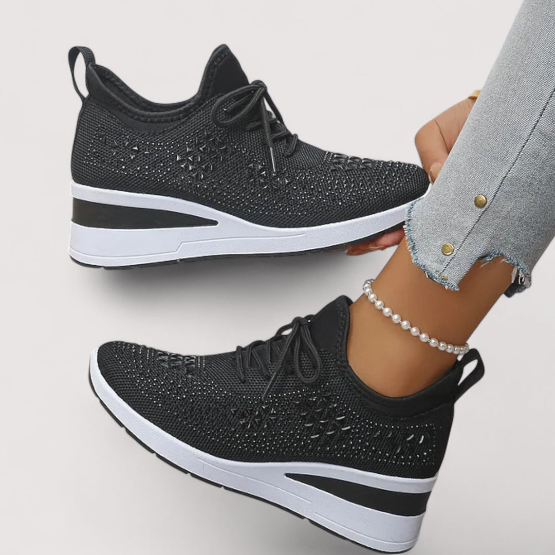 Eine Frau trägt die bequemen weißen Sneaker mit Glitzer-Details im urbanen Stil.