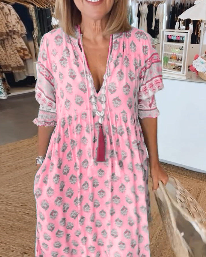 Bedrucktes Damen Midikleid mit V-Ausschnitt auf einem Model. Zeigt die fließende Passform und den Print.