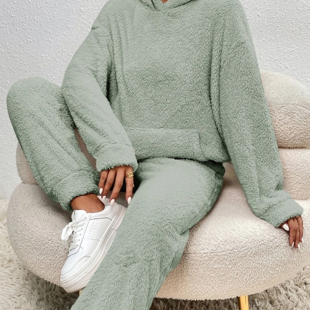 Frau im bequemen Frühlings-Loungewear-Set, Kapuzenpullover und passende Jogginghose, Casual-Look.