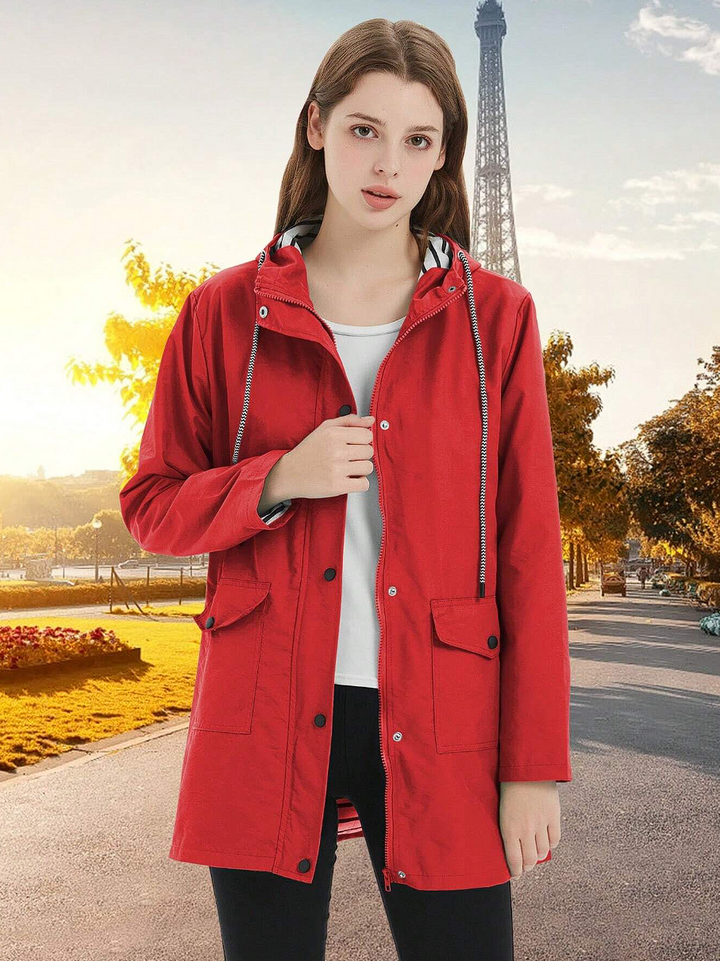 Aktive Frau in winddichter und wasserdichter Damen Outdoorjacke, bereit für die nächste Wanderung im Freien.