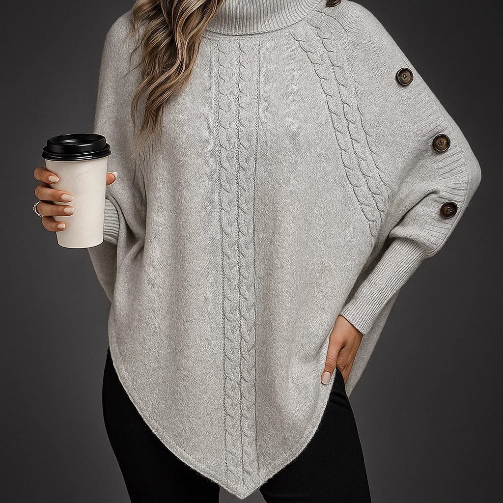 Eleganter Damen Poncho: Detailaufnahme des strukturierten Strickmusters & stilvoller Knopfdetails am Rollkragen.