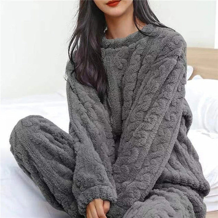 Nahaufnahme des flauschigen Strick-Damenpyjamas mit Zopfmuster. Komfortabler Zweiteiler für entspannte Winterabende.