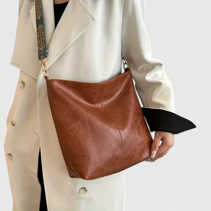 Nahaufnahme einer stilvollen Damen Schultertasche in Braun, zeigt einzigartiges Webmuster; elegantes Sommer-Accessoire.