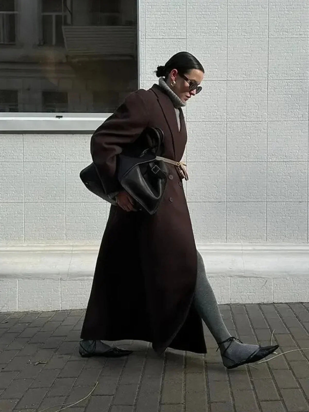 Modell trägt übergroßen, doppelreihigen, braunen Damen Trenchcoat. Eleganter langer Mantel für Herbstmode.