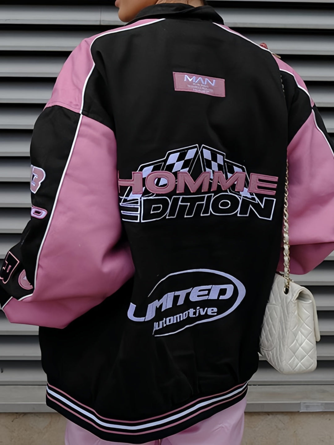 Frontansicht der schwarz-pinken Damen Raglanjacke im Vintage Motorradstil mit auffälligem Slogan-Print.