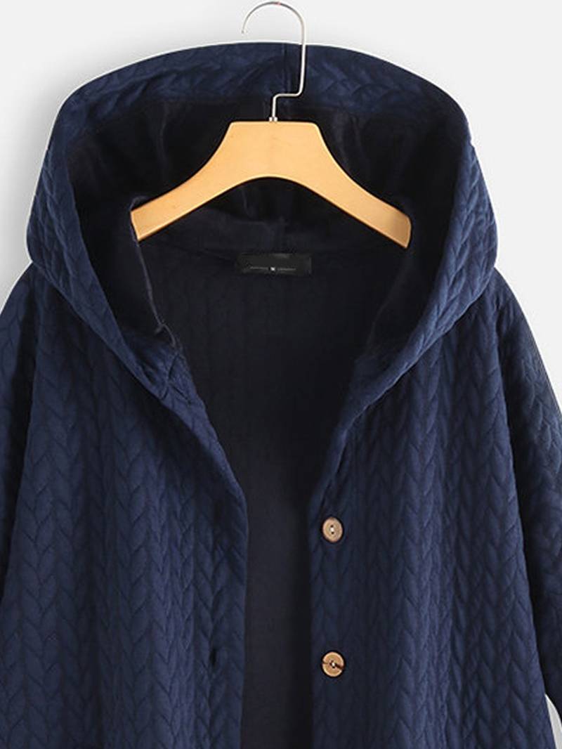 Frau sitzt, trägt bequeme, warme Damen-Freizeitjacke mit Knöpfen, entspannter Look.
