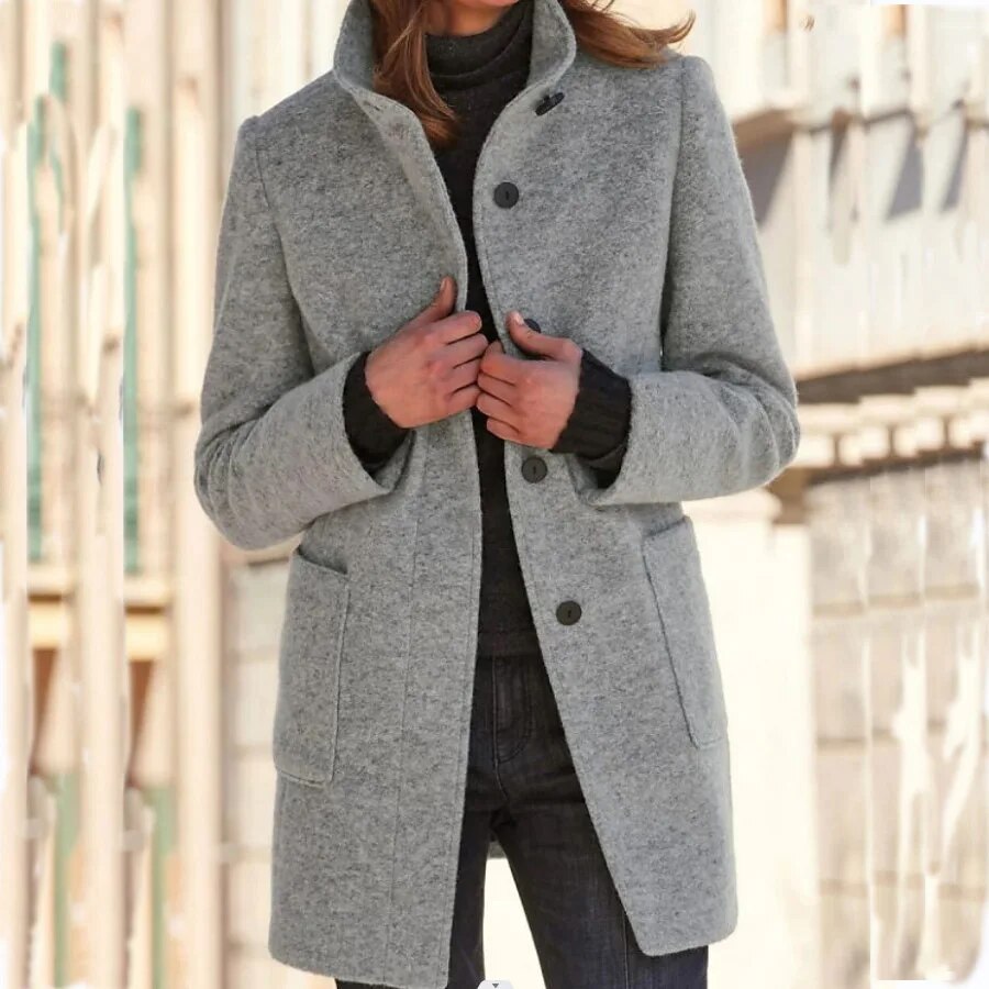 Nahaufnahme der stilvollen Knöpfe am eleganten Damen Wintermantel, ideal für Business Casual Outfits.