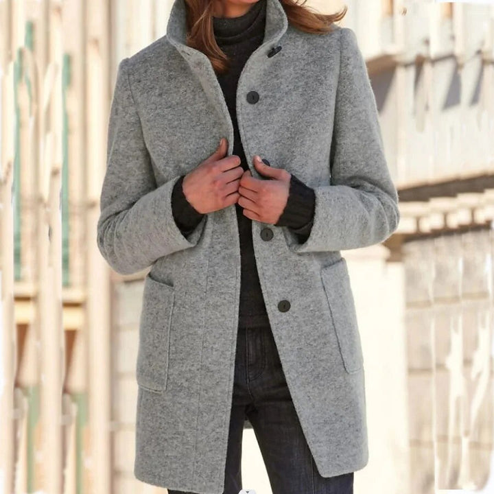 Nahaufnahme der stilvollen Knöpfe am eleganten Damen Wintermantel, ideal für Business Casual Outfits.