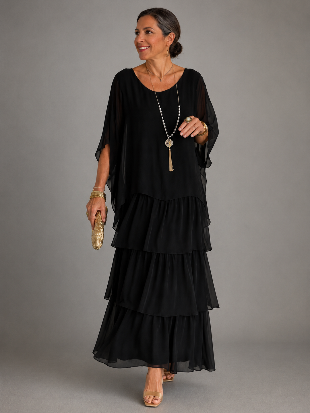 Model in a black flowing maxi dress with layered design