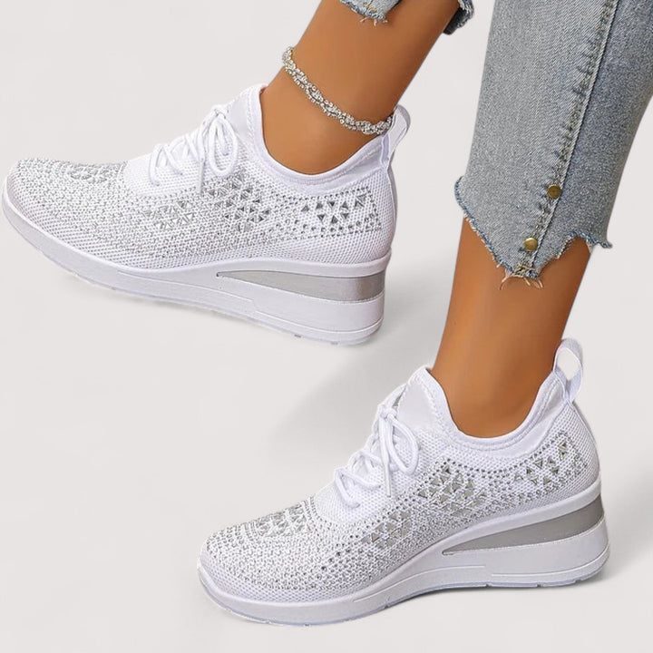 Komfortable Damen Turnschuhe in Weiß mit funkelnden Details an den Füßen einer Frau.