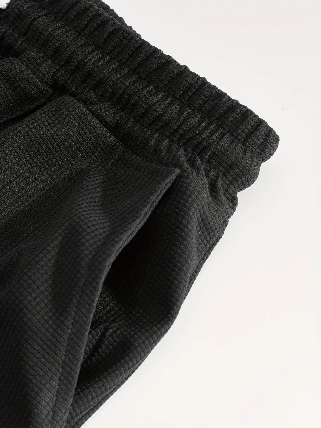 Detailaufnahme der Shorts aus dem Herren Sportset mit elastischem Bund und Waffelstrick