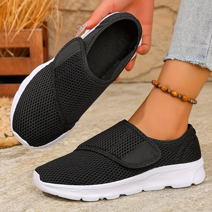 Damen Slip-On Sneaker in Schwarz mit weißer Sohle und verstellbarem Riemen