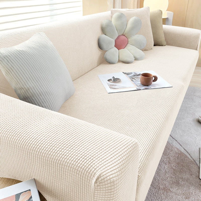 "Elastischer Sofabezug in Beige auf einem Sofa, stilvoller Schutz, passt perfekt durch Flexibilität, für Wohnzimmereinrichtun