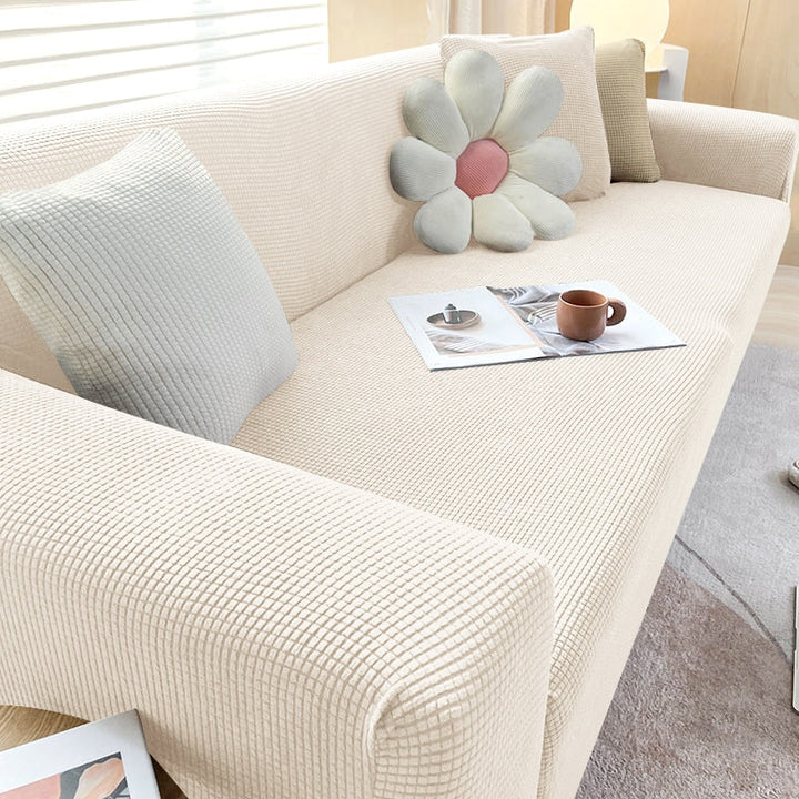 "Elastischer Sofabezug in Beige auf einem Sofa, stilvoller Schutz, passt perfekt durch Flexibilität, für Wohnzimmereinrichtun