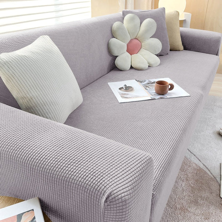 "Elastischer Sofabezug in Beige auf einem Sofa, stilvoller Schutz, passt perfekt durch Flexibilität, für Wohnzimmereinrichtun