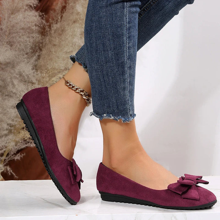 Seitenansicht der Damen Ballerinas. Flache, modische und bequeme Frühlingsschuhe mit dezenter Schleife.