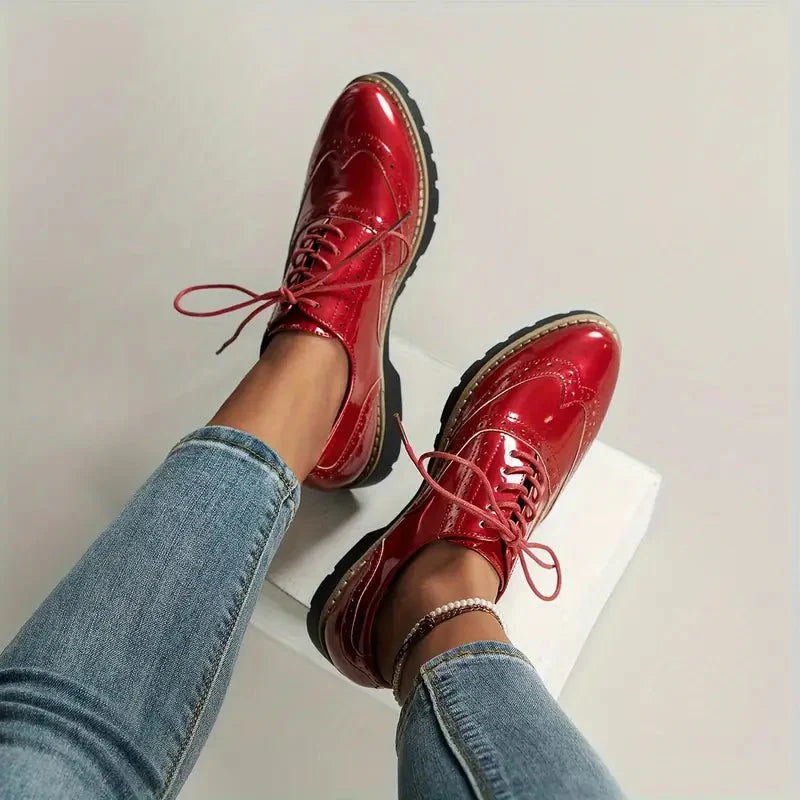 Elegante Damen-Lederpumps in glänzendem Lackleder mit Brogue-Details, vielseitig und komfortabel für jeden Anlass.