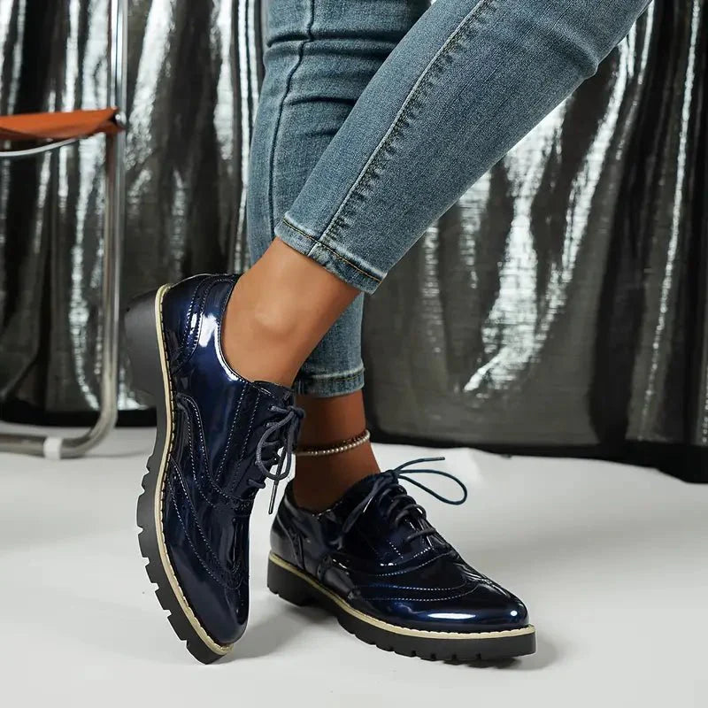 Elegante Damen-Lederpumps in glänzendem Lackleder mit Brogue-Details, vielseitig und komfortabel für jeden Anlass.