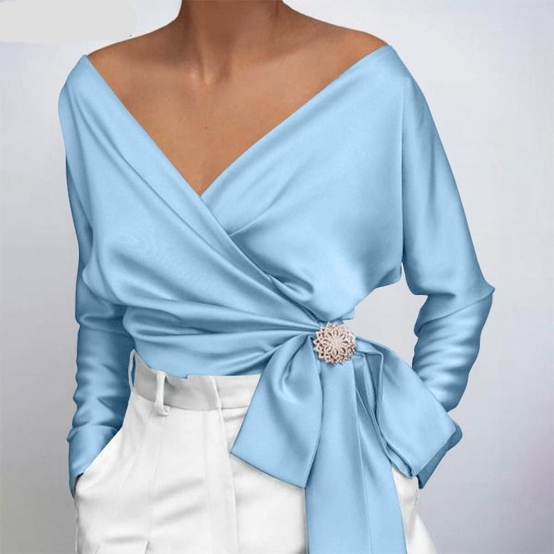 Nahaufnahme der glänzenden Stofftextur einer eleganten Damenbluse. Hochwertige feminine Mode.