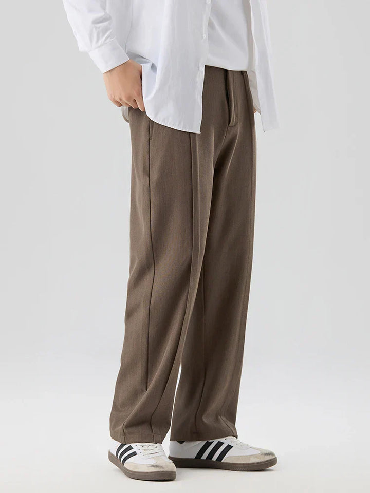 Stilvolle Herren-Bundfaltenhose aus Stoff, kombiniert Eleganz mit Bequemlichkeit für den modernen Mann.