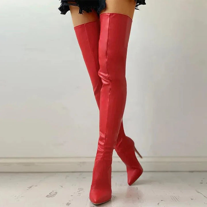"Elegante oberschenkelhohe Stiletto-Stiefel mit glänzendem Finish und schlankem Absatz, der das Bein optisch verlängert."