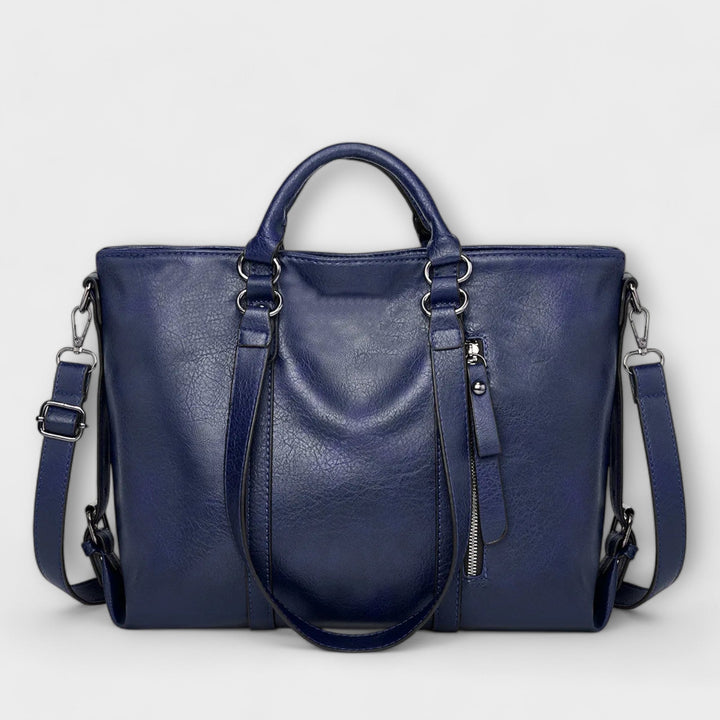 Damen-Arbeitstasche auf Bürotisch mit Laptop, elegante Businesstasche für Organisation und stilvollen Berufsalltag.