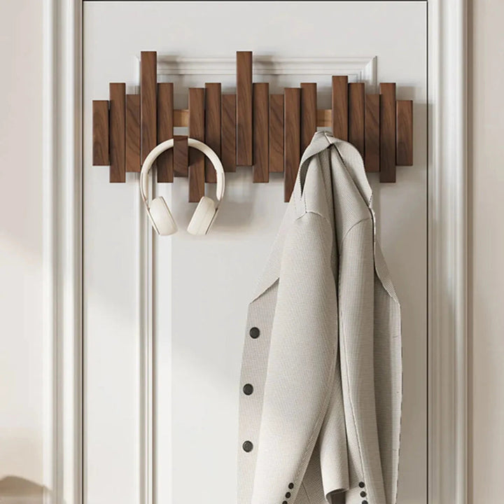 Elegante Wandgarderobe aus massivem Nussbaumholz mit mehreren Garderobenhaken für den Eingangsbereich.