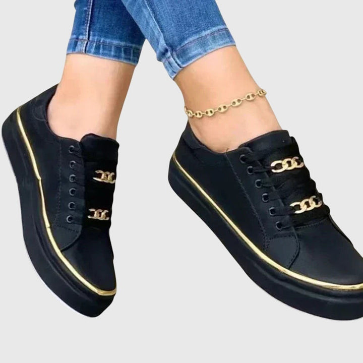 Eleganter Damen Samt-Sneaker Nicole in Schwarz mit goldenen Details, perfekt für modische Frühlings-Alltagslooks.