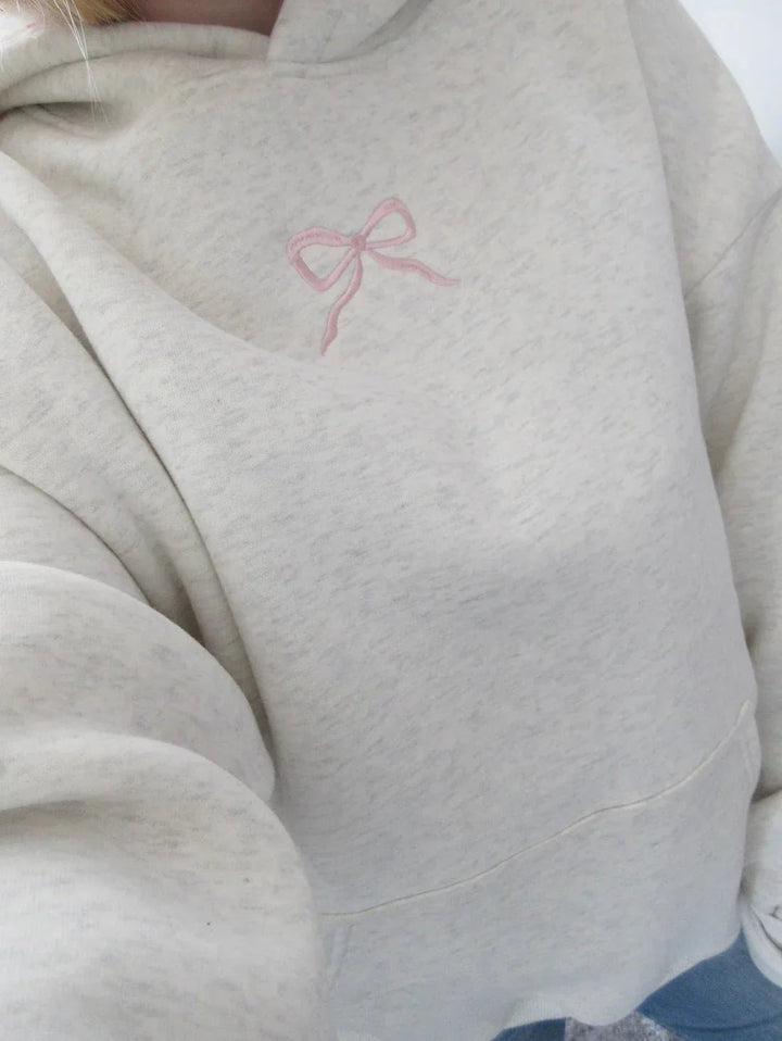 Eleganter elfenbein Damen Hoodie mit Kapuze, Kängurutasche und zarter rosa Schleife; bequem für Freizeit & Alltag.