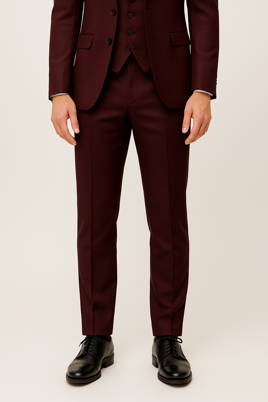 Bordeauxroter Dreiteiler Anzug für Herren, liegend. Set aus Sakko, Weste und Hose für elegante Frühlingsmode.