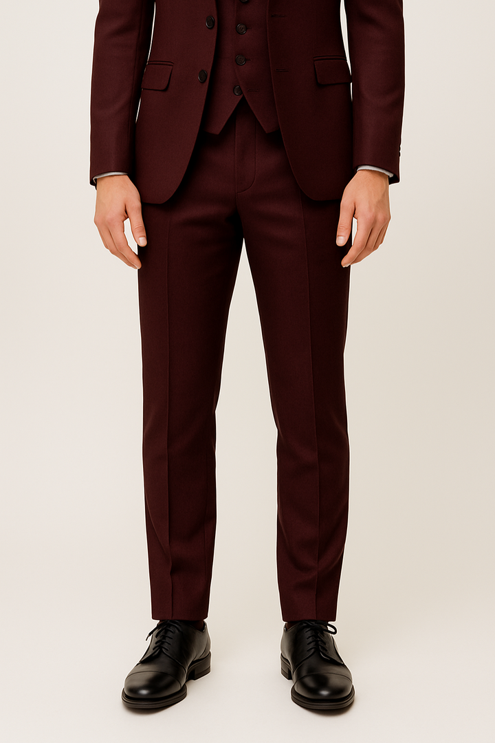 Bordeauxroter Dreiteiler Anzug für Herren, liegend. Set aus Sakko, Weste und Hose für elegante Frühlingsmode.
