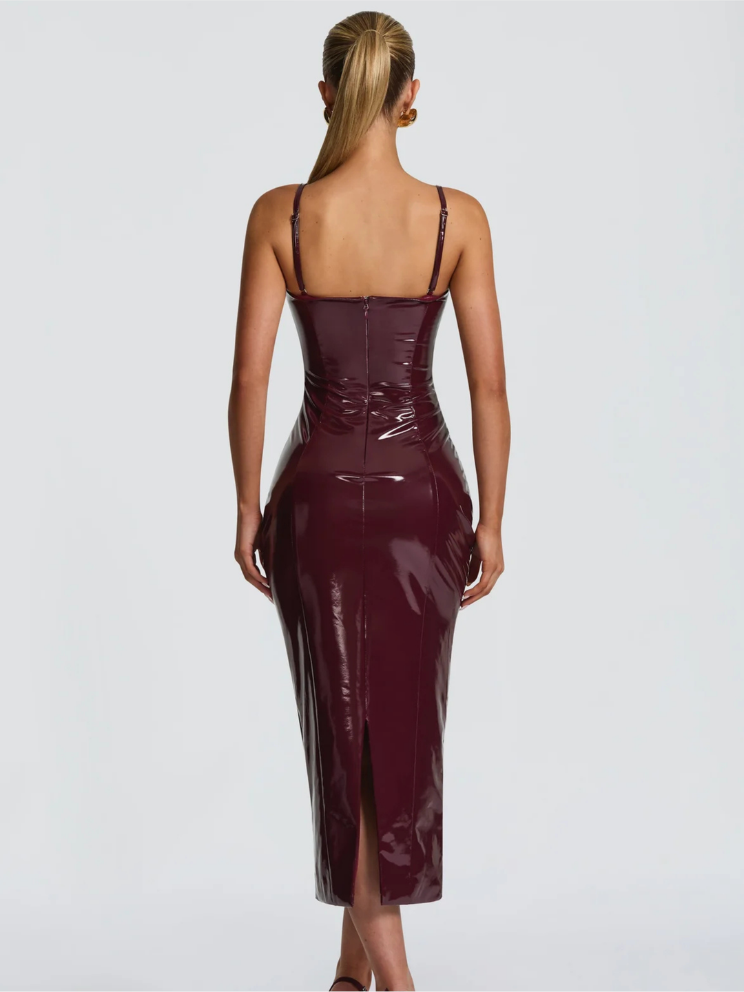 Dame trägt elegantes bordeauxrotes Abendkleid, langes festliches Kleid, schmeichelhafter figurbetonter Schnitt.