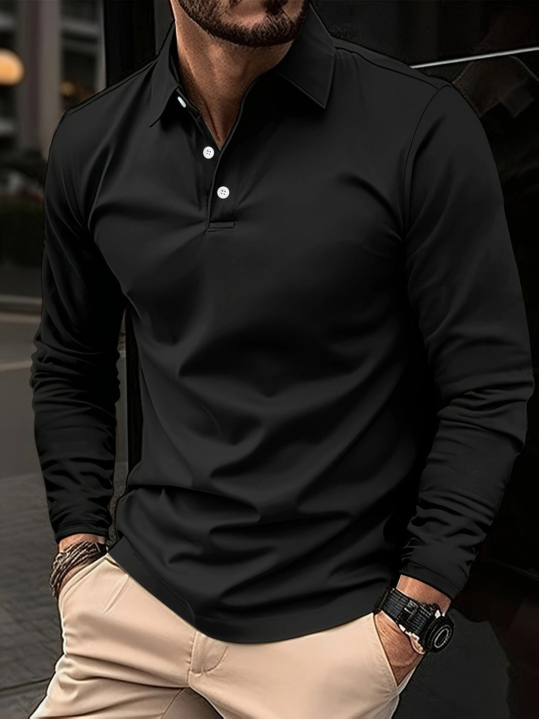 Mann trägt schwarzes Langarm Polohemd, schmale Passform, elegant für den Alltag.