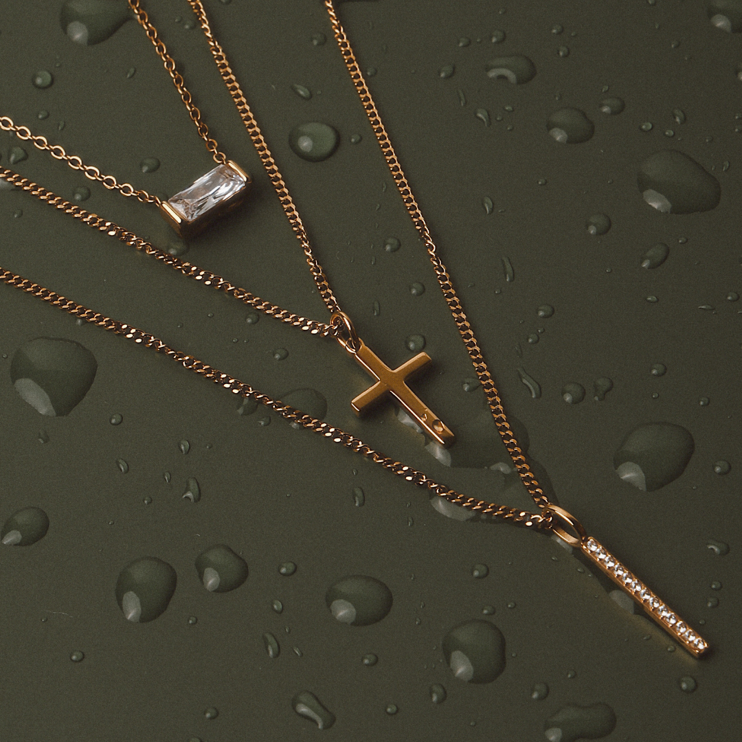 Nahaufnahme: Minimalistisches Gold Kreuz an feiner Damenhalskette aus wasserfestem Edelstahl, elegant & modern.