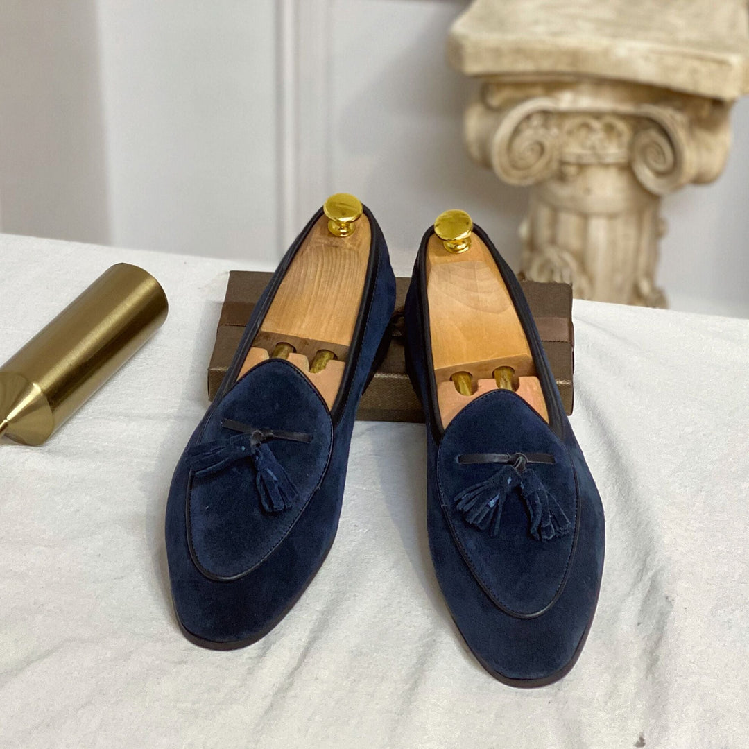Blaue Herren Loafer mit Quasten und Holzsohle auf einem Tisch präsentiert