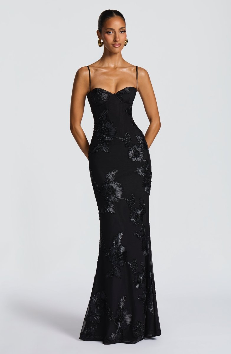 Vorderansicht des eleganten schwarzen Bodycon Maxikleids mit floralen Applikationen und Spaghettiträgern an einem Model