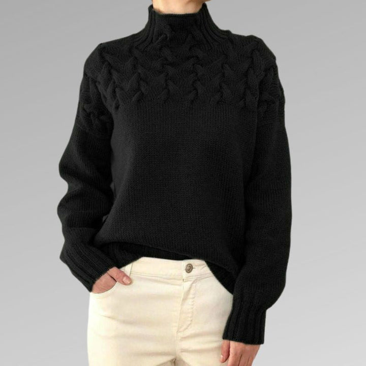 Modell trägt eleganten Damen Rollkragen Zopfmusterpullover. Langarm, warm & stilvoll für Herbstmode.