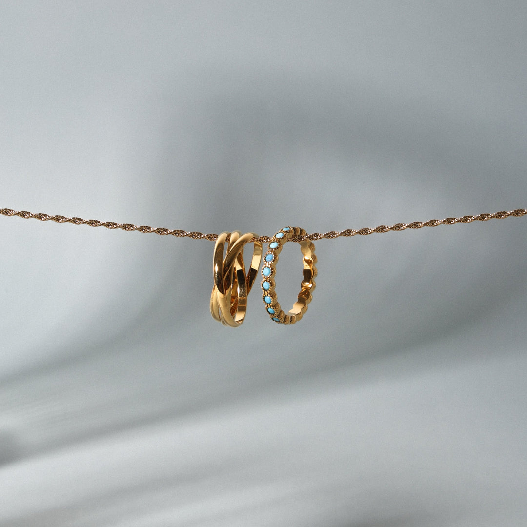 Damenring in Gold mit türkisblauen Akzenten, elegant kombiniert
