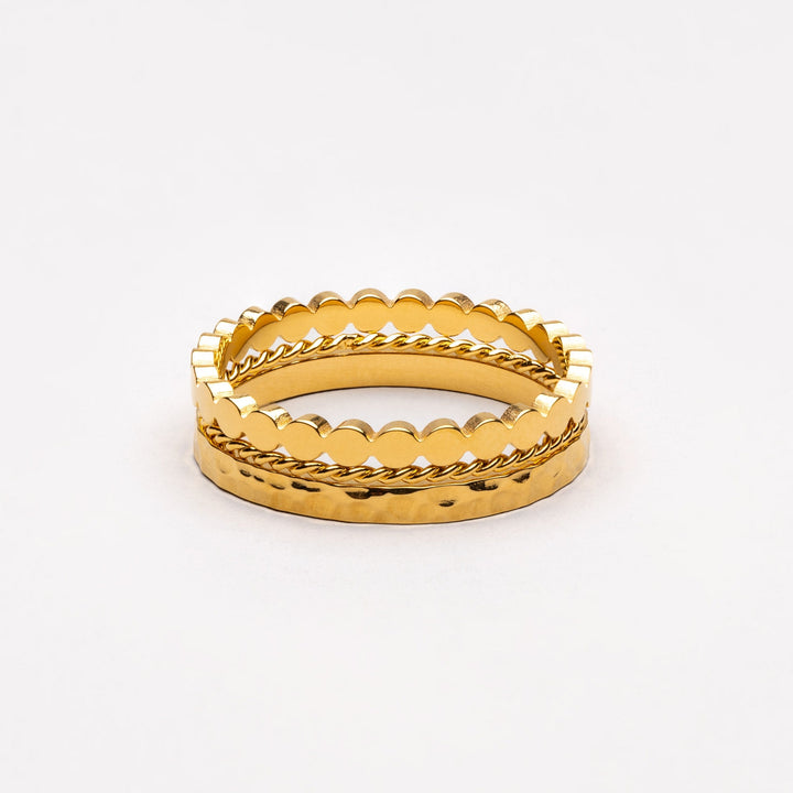 Ineinandergestapeltes goldenes Ring-Set auf hellem Hintergrund