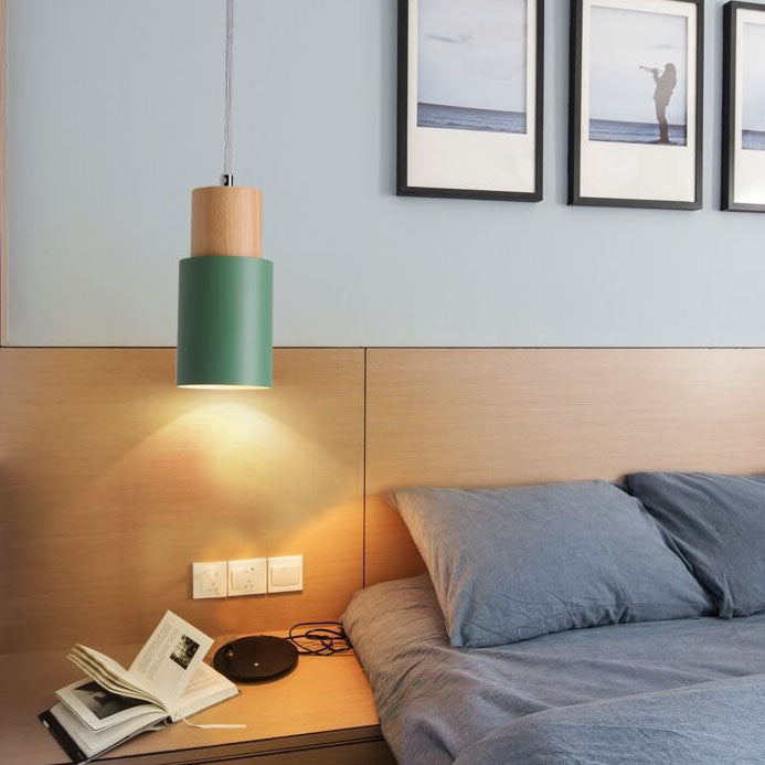 Grüne Hängeleuchte aus Holz über Nachttisch mit Buch, modernes Schlafzimmer, skandinavisches Design.