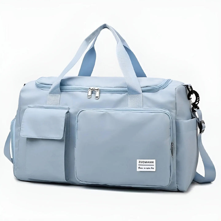 Hellblaue Reisetasche mit mehreren Fächern, Reißverschluss, Schultergurt, ideal für Reisen.