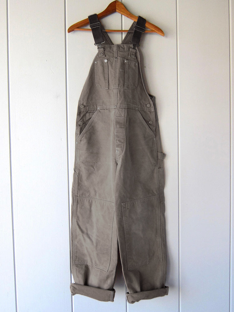 Herren Canvas Latzhose als funktionale Arbeitskleidung im Garten, robust und vielseitig nutzbar.