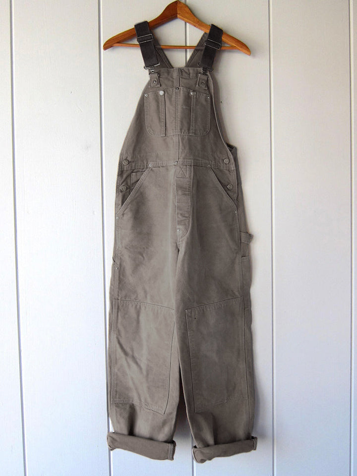 Herren Canvas Latzhose als funktionale Arbeitskleidung im Garten, robust und vielseitig nutzbar.