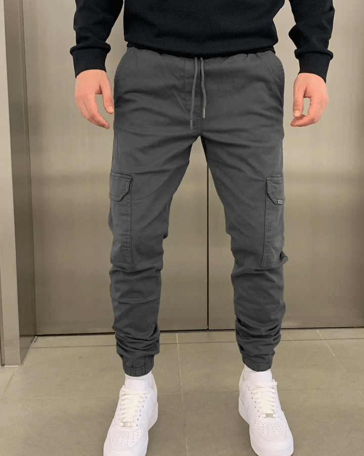 Herren Cargo-Jogger neben Sneakern & T-Shirt, zeigt Styling-Möglichkeiten für den Alltagslook.